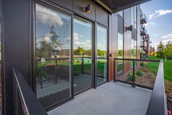 a balcony with glass doors and a view of a yard